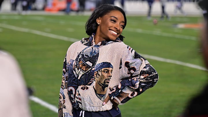 Dec 26, 2024; Chicago, Illinois, USA; United States gymnast Simone Biles poses for a photo on the sidelines before the game between the Chicago Bears and the Seattle Seahawks at Soldier Field. 