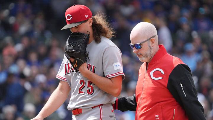 May 7, 2026; Chicago, Illinois, USA; Cincinnati Reds pitcher Rhett Lowder (25) leaves the game against the Chicago Cubs with the team trainer during the fourth inning at Wrigley Field. Mandatory Credit: David Banks-Imagn Images