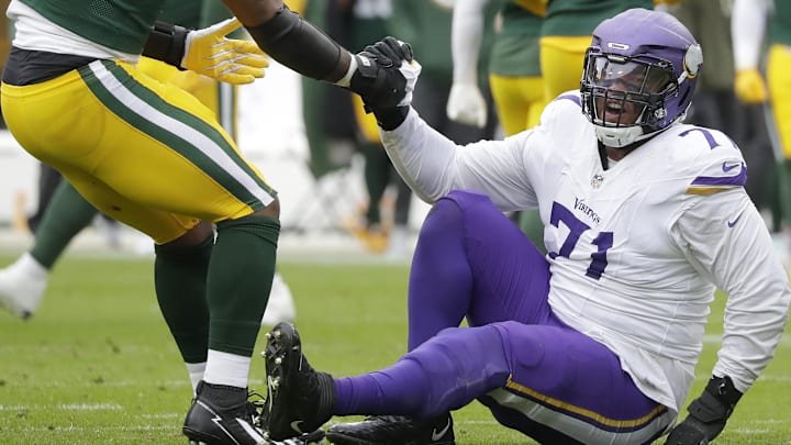 Nov 23, 2025; Green Bay, Wisconsin, USA; Green Bay Packers defensive end Micah Parsons (1) helps Minnesota Vikings offensive tackle Christian Darrisaw (71) off the ground at Lambeau Field.