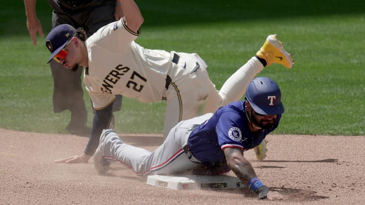 Texas Rangers outfielder Derek Hill (40) beats a tag by Milwaukee Brewers shortstop Willy Adames (27) to steal second base during the sixth inning of their game Wednesday, June 26, 2024 at American Family Field in Milwaukee, Wisconsin.