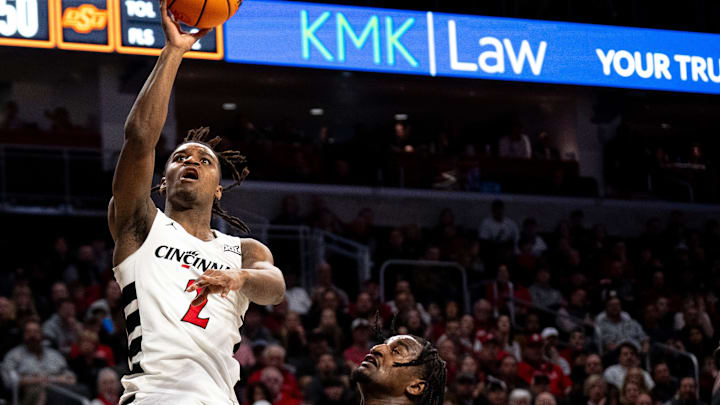 Cincinnati Bearcats guard Jizzle James (2) hits a basket Oklahoma State Cowboys guard John-Michael Wright (51) in the second half of the NCAA basketball game between Cincinnati Bearcats and Oklahoma State Cowboys at Fifth Third Arena in Cincinnati on Wednesday, Feb. 21, 2024.