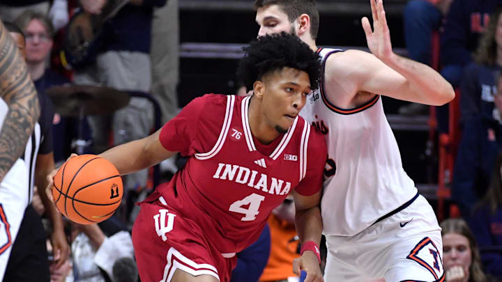 Feb 15, 2026; Champaign, Illinois, USA; Indiana Hoosiers forward Sam Alexis (4) drives the ball against Illinois Fighting Illini center Tomislav Ivisic (13) during the first half at State Farm Center. 