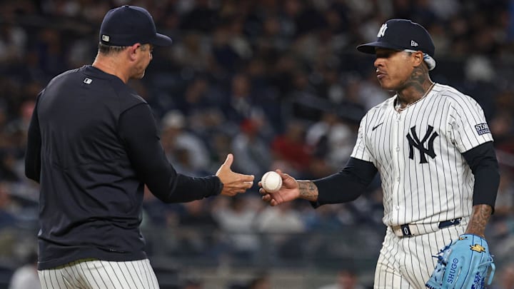 Sep 10, 2024; Bronx, New York, USA; New York Yankees starting pitcher Marcus Stroman (0) hands the ball to manager Aaron Boone (17) after being relieved sixth inning against the Kansas City Royals at Yankee Stadium. Mandatory Credit: Vincent Carchietta-Imagn Images