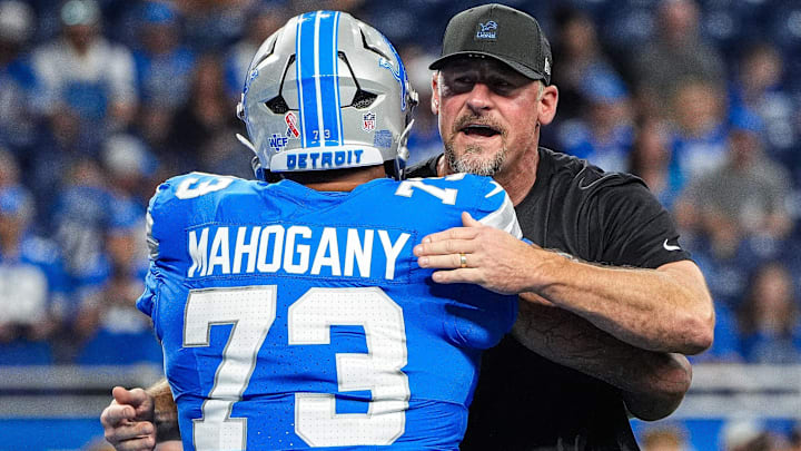 Detroit Lions head coach Dan Campbell hugs guard Christian Mahogany (73) during warm up at Ford Field in Detroit on Sunday, Sept. 14, 2025.