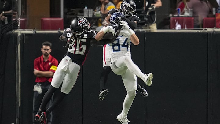Aug 15, 2025; Atlanta, Georgia, USA; Tennessee Titans tight end Gunnar Helm (84) catches a touchdown pass defended by Atlanta Falcons safety Jordan Fuller (29) and safety Ronnie Harrison (36) during the first half at Mercedes-Benz Stadium. Mandatory Credit: Dale Zanine-Imagn Images
