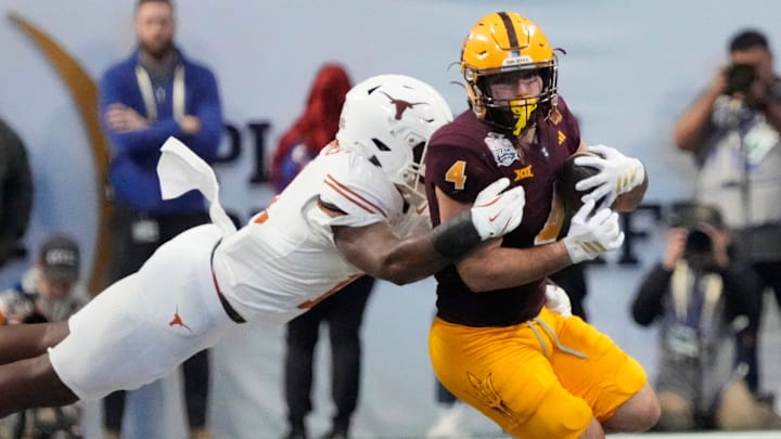 Arizona State running back Cam Skattebo (4) is tackled by Texas linebacker Colin Simmons (11) during the fourth quarter in the Chick-fil-A Peach Bowl in Atlanta on Wednesday, Jan. 1, 2025.