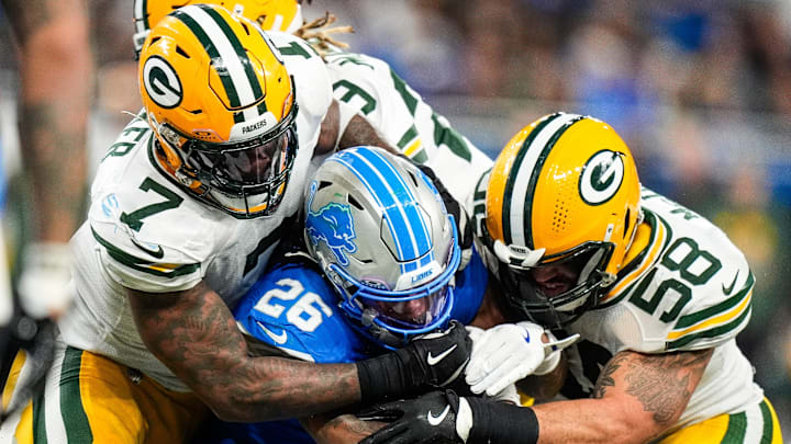 Green Bay Packers linebacker Quay Walker (7) helps tackle Lions running back Jahmyr Gibbs.