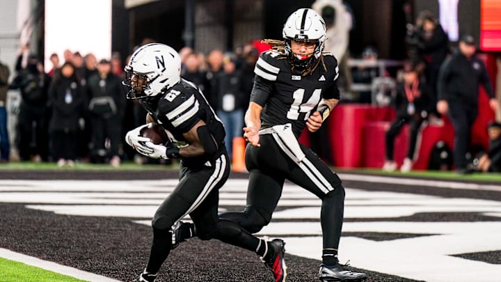 Nov 1, 2025; Lincoln, Nebraska, USA; Nebraska Cornhuskers quarterback TJ Lateef (14) hands the ball off to running back Emmett Johnson (21) against the Southern California Trojans during the fourth quarter at Memorial Stadium. 