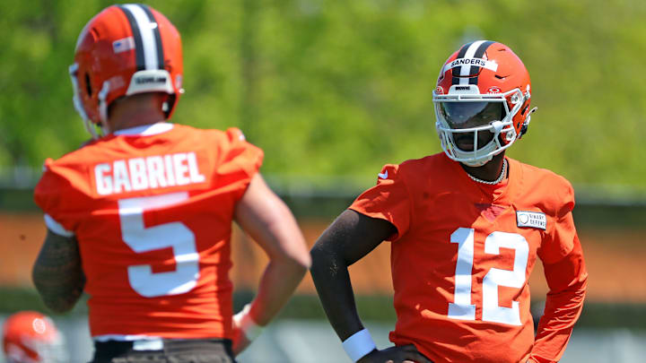 Cleveland Browns quarterback Shedeur Sanders (12) watches quarterback Dillon Gabriel (5) during day two of NFL rookie minicamp at the Cleveland Browns training facility on Saturday, May 10, 2025, in Berea, Ohio.