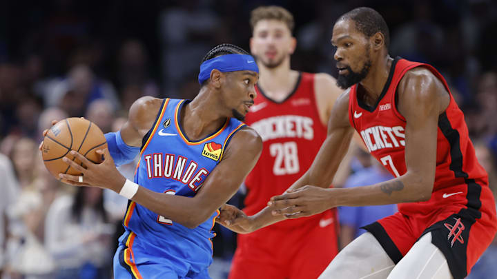 Oct 21, 2025; Oklahoma City, Oklahoma, USA; Oklahoma City Thunder guard Shai Gilgeous-Alexander (2) keeps the ball away from Houston Rockets forward Kevin Durant (7) during the second half at Paycom Center. Mandatory Credit: Alonzo Adams-Imagn Images