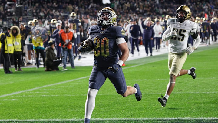 Nov 23, 2024; New York, New York, USA; Notre Dame Fighting Irish running back Aneyas Williams (20) scores a rushing touchdown as Army Black Knights defensive back Josiah Banks (25) pursues during the second half at Yankee Stadium. Mandatory Credit: Vincent Carchietta-Imagn Images