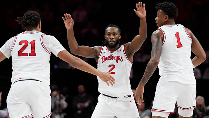 Ohio State Buckeyes guard Bruce Thornton (2) celebrates a three pointer with forward Devin Royal (21) and forward Amare Bynum (1) during the first half of the NCAA men's basketball game against the Illinois Fighting Illini in Columbus on Dec. 9, 2025. Ohio State Buckeyes guard Bruce Thornton (2) celebrates a three pointer with forward Devin Royal (21) and forward Amare Bynum (1) during the first half of the NCAA men's basketball game against the Illinois Fighting Illini in Columbus on Dec. 9, 2025.