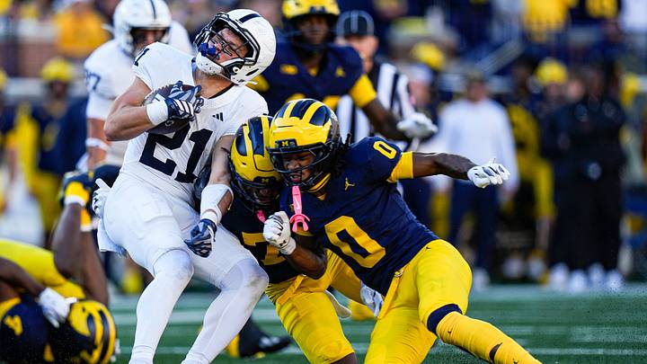 Michigan safety Chris Bracy (7) and cornerback Jyaire Hill (0) tackle Penn State running back Carson Hansen (21) during the first half at Michigan Stadium in Ann Arbor on Saturday, Oct. 17, 2026.