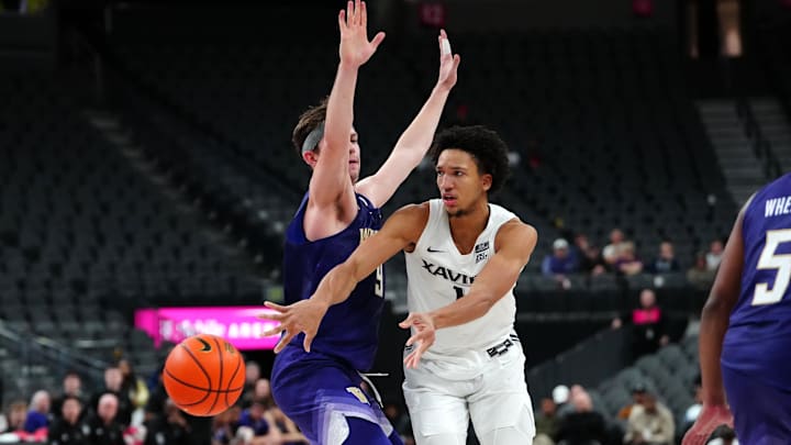  Xavier Musketeers guard Desmond Claude (1) throw a pass under the guard of Washington's Paul Mulcahy (9) in 2023.