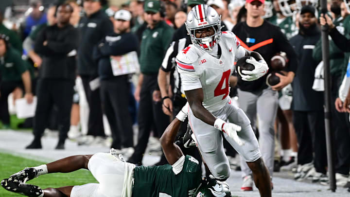 Sep 28, 2024; East Lansing, Michigan, USA; Ohio State Buckeyes wide receiver Jeremiah Smith (4) runs past Michigan State Spartans defensive back Ed Woods (4) in the first quarter at Spartan Stadium. Mandatory Credit: Dale Young-Imagn Images Sep 28, 2024; East Lansing, Michigan, USA; Ohio State Buckeyes wide receiver Jeremiah Smith (4) runs past Michigan State Spartans defensive back Ed Woods (4) in the first quarter at Spartan Stadium. Mandatory Credit: Dale Young-Imagn Images
