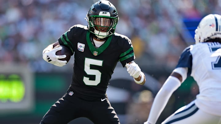 Oct 5, 2025; East Rutherford, New Jersey, USA; New York Jets wide receiver Garrett Wilson (5) carries the ball after the catch against the Dallas Cowboys during the first half at MetLife Stadium. Mandatory Credit: Vincent Carchietta-Imagn Images