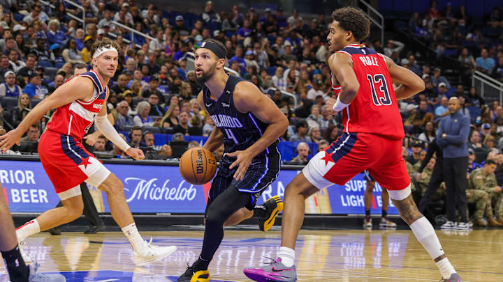 Orlando Magic guard Jalen Suggs (4) drives to the basket around Washington Wizards guard Jordan Poole (13) during the second half at Kia Center.