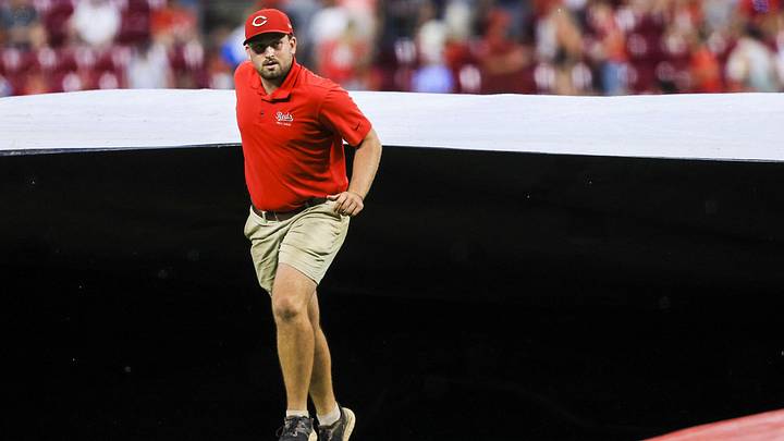 Aug 12, 2025; Cincinnati, Ohio, USA; A member of the grounds crew pulls the tarp over the field during a rain delay in the seventh inning in the game between the Philadelphia Phillies and the Cincinnati Reds at Great American Ball Park. Mandatory Credit: Katie Stratman-Imagn Images Aug 12, 2025; Cincinnati, Ohio, USA; A member of the grounds crew pulls the tarp over the field during a rain delay in the seventh inning in the game between the Philadelphia Phillies and the Cincinnati Reds at Great American Ball Park. Mandatory Credit: Katie Stratman-Imagn Images