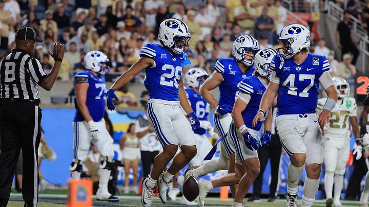 Dec 27, 2025; Orlando, FL, USA; BYU Cougars running back Jovesa Damuni (28) is congratulated after scoring a touchdown against the Georgia Tech Yellow Jackets during the second half at Camping World Stadium. Mandatory Credit: Kim Klement Neitzel-Imagn Images
