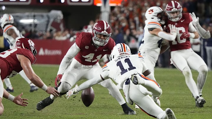 Nov 30, 2024; Tuscaloosa, Alabama, USA;  Auburn Tigers wide receiver Malcolm Simmons (11) fumbles a punt but recovers as Alabama Crimson Tide defensive back Prince Butler (48) and linebacker Justin Okoronkwo (41) close in during second half at Bryant-Denny Stadium. Alabama won 28-14. Mandatory Credit: Gary Cosby Jr.-Imagn Images