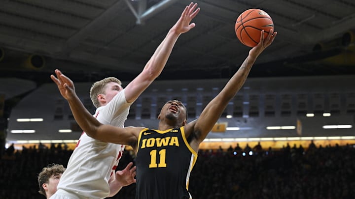 Feb 17, 2024; Iowa City, Iowa, USA; Iowa Hawkeyes guard Tony Perkins (11) shoots the ball with a hand in his face.