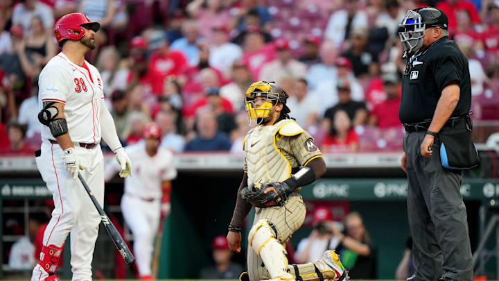 Cincinnati Reds designated hitter Mike Ford (38) disagrees with a called strike three with home plate umpire Hunter Wendelstedt (21) in the sixth inning of a baseball game against the San Diego Padres, Tuesday, May 21, 2024, at Great American Ball Park in Cincinnati. The Cincinnati Reds won, 2-0.