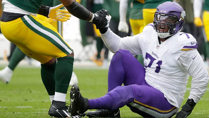 Green Bay Packers defensive end Micah Parsons (1) helps Minnesota Vikings offensive tackle Christian Darrisaw (71) off the ground on Sunday, November 23, 2025, at Lambeau Field in Green Bay, Wis. The Packers defeated the Vikings 23-6