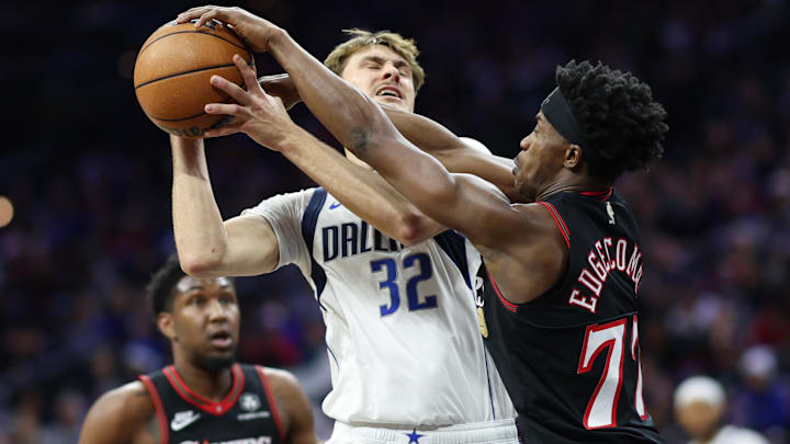 Dec 20, 2025; Philadelphia, Pennsylvania, USA; Philadelphia 76ers guard Vj Edgecombe (77) fouls as he blocks the drive of Dallas Mavericks forward Cooper Flagg (32) during the second quarter at Xfinity Mobile Arena. Mandatory Credit: Bill Streicher-Imagn Images
