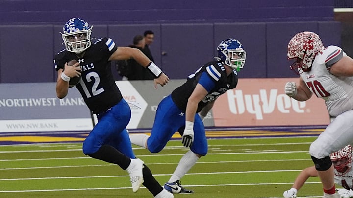 MMCRU's quarterback Eli Harpenau (12) runs with the ball for a first down against MMCRU during the first quarter in the class-A state football championship on Nov. 20, 2025, at UNI Dome in Cedar Falls, Iowa.