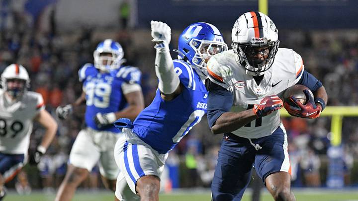 Nov 15, 2025; Durham, North Carolina, USA;  Duke Blue Devils cornerback Chandler Rivers (0) attempts to swat the ball from Virginia Cavaliers wide receiver Trell Harris (11) during the third quarter at Wallace Wade Stadium. Mandatory Credit: Zachary Taft-Imagn Images