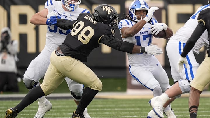 Nov 30, 2024; Winston-Salem, North Carolina, USA;  Wake Forest Demon Deacons defensive lineman Mateen Ibirogba (99) reaches out for Duke Blue Devils running back Star Thomas (17) during the second half at Allegacy Federal Credit Union Stadium. Mandatory Credit: Jim Dedmon-Imagn Images