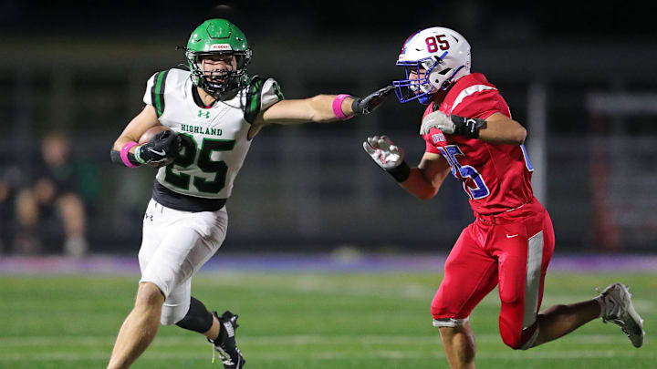 Highland running back Casey Myser, left, picks up yards against Revere defensive end Michael Mark during the first half of a high school football game, Oct. 17, 2025, in Bath Township, Ohio.