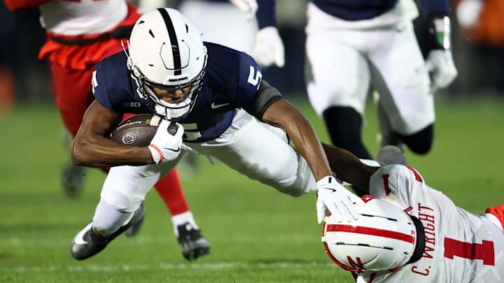 Nov 22, 2025; University Park, Pennsylvania, USA; Penn State Nittany Lions wide receiver Devonte Ross (5) runs with the ball before being tackled by Nebraska Cornhuskers defensive back Ceyair Wright (1) during the second quarter at Beaver Stadium. 