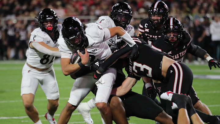 Sep 28, 2024; Lubbock, Texas, USA;  Cincinnati Bearcats quarterback Brendan Sorsby (2) is tackled by Texas Tech Red Raiders defensive back Ben Roberts (13) in the second half at Jones AT&T Stadium and Cody Campbell Field. Mandatory Credit: Michael C. Johnson-Imagn Images