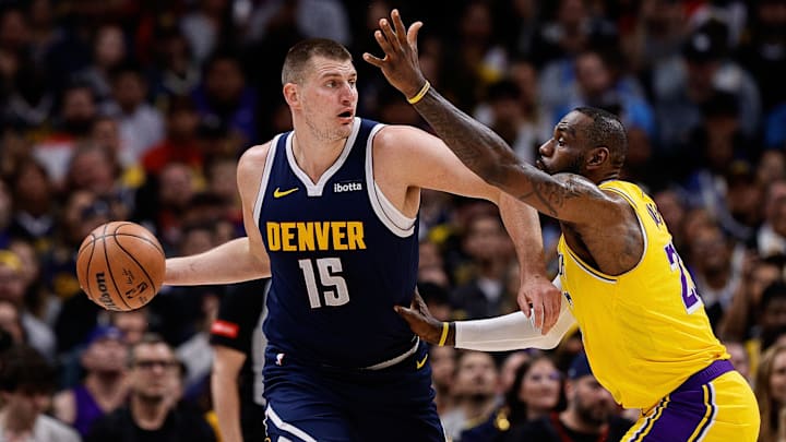 Apr 29, 2024; Denver, Colorado, USA; Denver Nuggets center Nikola Jokic (15) controls the ball under pressure from Los Angeles Lakers forward LeBron James (23) in the first quarter during game five of the first round for the 2024 NBA playoffs at Ball Arena.