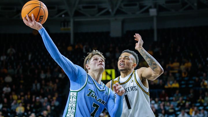 Feb 23, 2025; Wichita, Kansas, USA; Tulane Green Wave guard Rowan Brumbaugh (7) shoots the ball around Wichita State Shockers guard Xavier Bell (1) during the first half at Charles Koch Arena. 