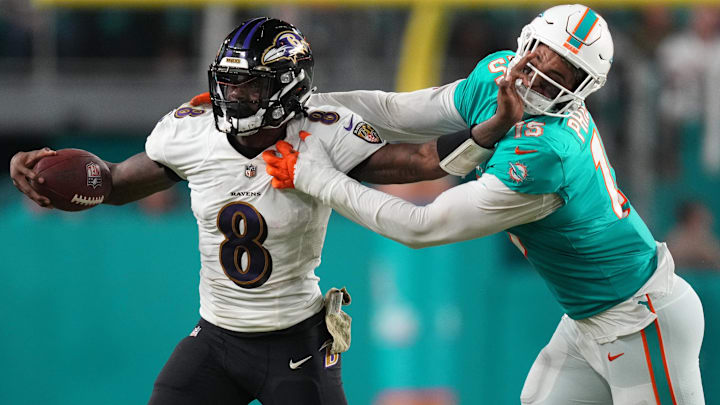 Nov 11, 2021; Miami Gardens, Florida, USA; Baltimore Ravens quarterback Lamar Jackson (8) stiff arms Miami Dolphins outside linebacker Jaelan Phillips (15) during the second half at Hard Rock Stadium. Mandatory Credit: Jasen Vinlove-Imagn Images Nov 11, 2021; Miami Gardens, Florida, USA; Baltimore Ravens quarterback Lamar Jackson (8) stiff arms Miami Dolphins outside linebacker Jaelan Phillips (15) during the second half at Hard Rock Stadium. Mandatory Credit: Jasen Vinlove-Imagn Images