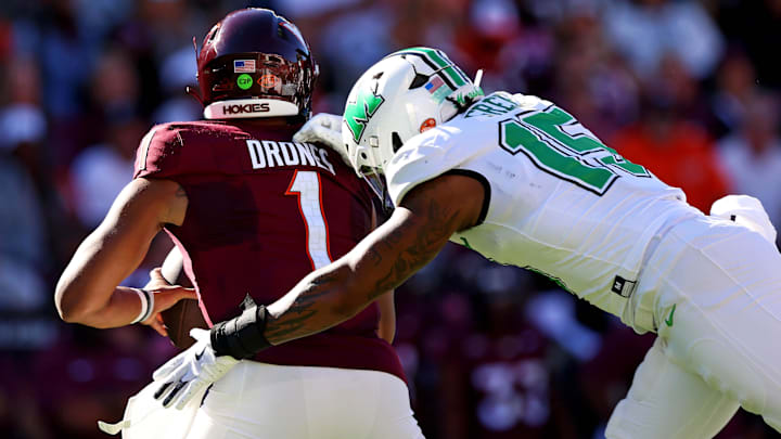 Sep 7, 2024; Blacksburg, Virginia, USA; Marshall Thundering Herd defensive lineman Mike Green (15) sacks Virginia Tech Hokies quarterback Kyron Drones (1) during the first quarter at Lane Stadium. Mandatory Credit: Peter Casey-Imagn Images Sep 7, 2024; Blacksburg, Virginia, USA; Marshall Thundering Herd defensive lineman Mike Green (15) sacks Virginia Tech Hokies quarterback Kyron Drones (1) during the first quarter at Lane Stadium. Mandatory Credit: Peter Casey-Imagn Images