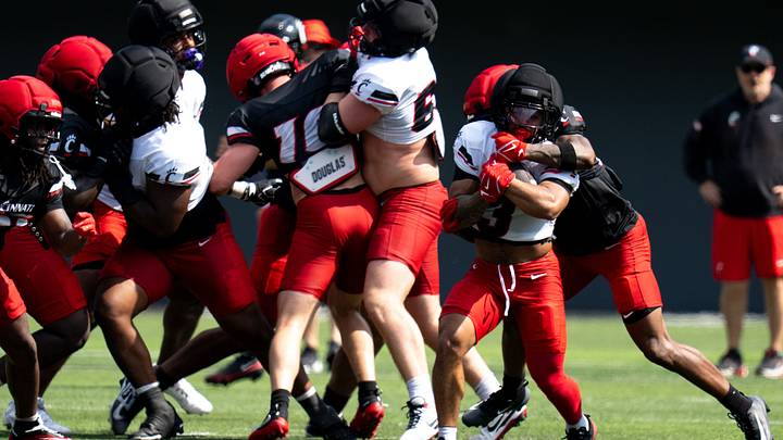 Cincinnati Bearcats running back Cole Tabb (3) is tackled by Cincinnati Bearcats defensive back Markell Taylor (27) during the Cincinnati Bearcats football practice at Nippert Stadium in Cincinnati on Saturday, Aug. 8, 2026. Cincinnati Bearcats running back Cole Tabb (3) is tackled by Cincinnati Bearcats defensive back Markell Taylor (27) during the Cincinnati Bearcats football practice at Nippert Stadium in Cincinnati on Saturday, Aug. 8, 2026.