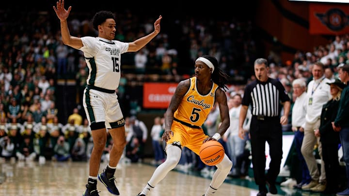 Feb 15, 2025; Fort Collins, Colorado, USA; Wyoming Cowboys guard Obi Agbim (5) controls the ball as Colorado State Rams guard Jalen Lake (15) guards in the first half at Moby Arena. Mandatory Credit: Isaiah J. Downing-Imagn Images