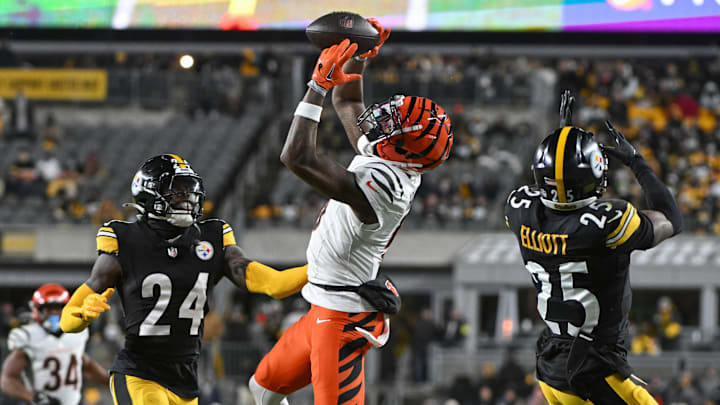 Jan 4, 2025; Pittsburgh, Pennsylvania, USA; Cincinnati Bengals wide receiver Tee Higgins (5) catches a pass in front of Pittsburgh Steelers cornerback Joey Porter Jr. (24) and safety DeShon Elliott (25) during the second quarter at Acrisure Stadium. Mandatory Credit: Barry Reeger-Imagn Images