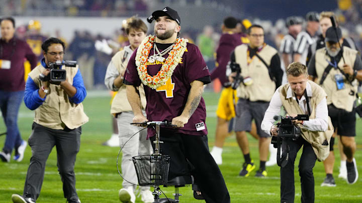 Former Arizona State running back Cam Skattebo rides a scooter toward the ASU fans to pump them up prior to a game against Arizona at Mountain America Stadium in Tempe, Ariz. on Nov. 28, 2025. Former Arizona State running back Cam Skattebo rides a scooter toward the ASU fans to pump them up prior to a game against Arizona at Mountain America Stadium in Tempe, Ariz. on Nov. 28, 2025.