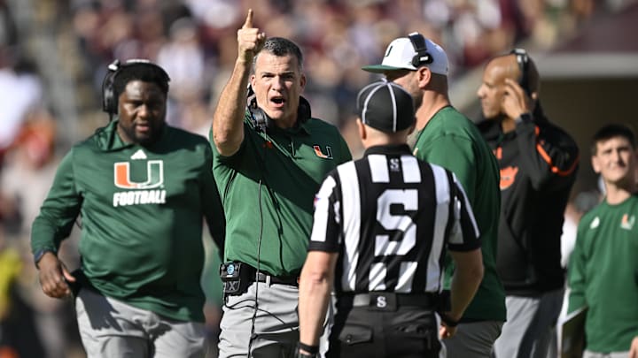 Dec 20, 2025; College Station, TX, USA; Miami Hurricanes head coach Mario Cristobal talks with an official during the second half of the first round game of the CFP National Playoff against the Texas A&M Aggies at Kyle Field. Mandatory Credit: Jerome Miron-Imagn Images