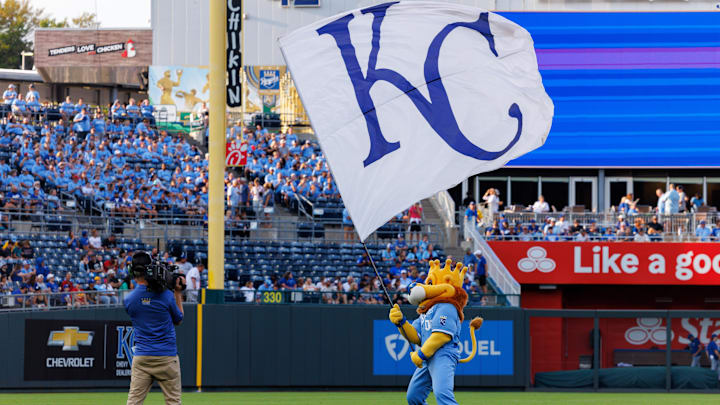 Sep 20, 2025; Kansas City, Missouri, USA; Kansas City Royals mascot Slugger waves the KC flag prior to the game against the Toronto Blue Jays at Kauffman Stadium. Mandatory Credit: William Purnell-Imagn Images