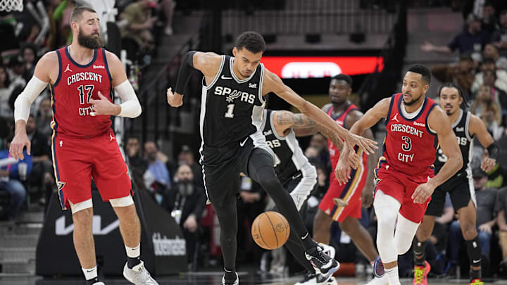 Feb 2, 2024; San Antonio, Texas, USA; San Antonio Spurs forward Victor Wembanyama (1) battles for a loose ball along with New Orleans Pelicans guard CJ McCollum (3) and center Jonas Valanciunas (17) during the second half at Frost Bank Center. Mandatory Credit: Scott Wachter-Imagn Images