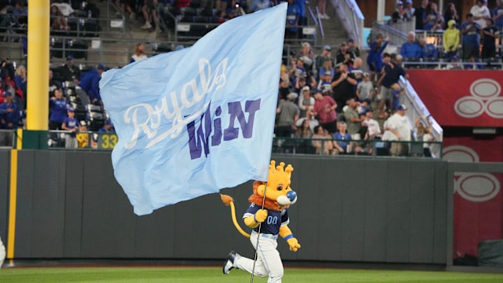 Sep 6, 2024; Kansas City, Missouri, USA; The Kansas City Royals mascot Sluggerrr runs on field with a large flag after the win over the Minnesota Twins at Kauffman Stadium. Mandatory Credit: Denny Medley-Imagn Images Sep 6, 2024; Kansas City, Missouri, USA; The Kansas City Royals mascot Sluggerrr runs on field with a large flag after the win over the Minnesota Twins at Kauffman Stadium. Mandatory Credit: Denny Medley-Imagn Images