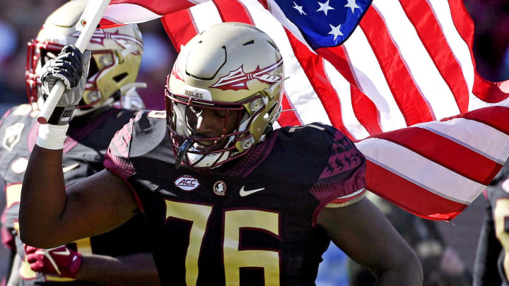 Nov 6, 2021; Tallahassee, Florida, USA; Florida State Seminoles offensive lineman Darius Washington (76) carries the American flag onto the field before the game against the North Carolina State Wolfpack at Doak S. Campbell Stadium. Mandatory Credit: Melina Myers-USA TODAY Sports Nov 6, 2021; Tallahassee, Florida, USA; Florida State Seminoles offensive lineman Darius Washington (76) carries the American flag onto the field before the game against the North Carolina State Wolfpack at Doak S. Campbell Stadium. Mandatory Credit: Melina Myers-USA TODAY Sports