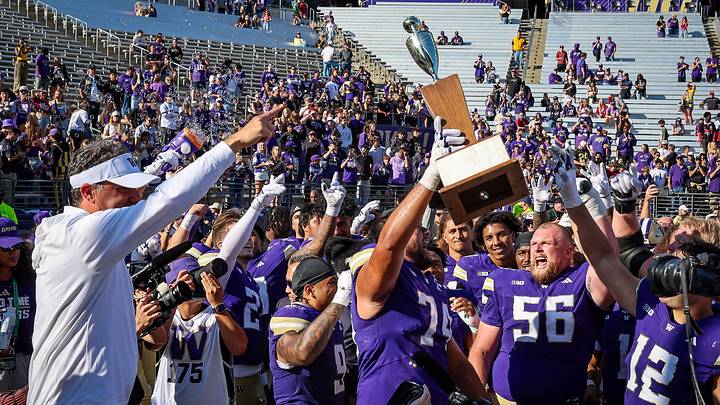 Jedd Fisch and his Huskies celebrate keeping the Apple Cup, held high by Drew Azzopardi.