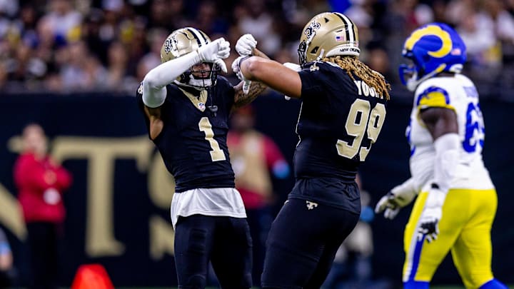 Dec 1, 2024; New Orleans, Louisiana, USA;  New Orleans Saints cornerback Alontae Taylor (1) and defensive end Chase Young (99) react to forcing a fourth down against the Los Angeles Rams during the first half at Caesars Superdome. Mandatory Credit: Stephen Lew-Imagn Images