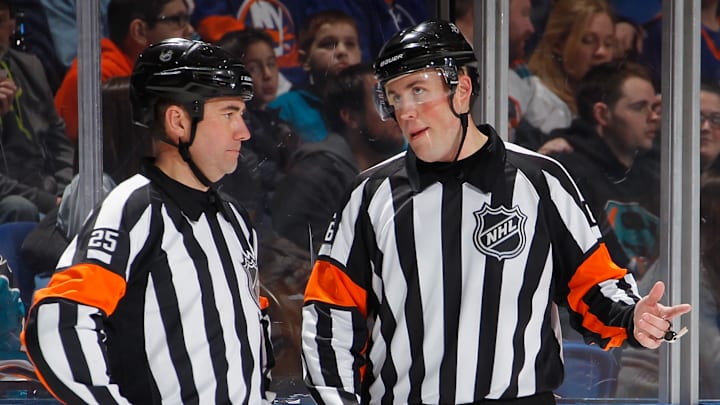 Referees speak during a break in NHL play (Getty Images)
